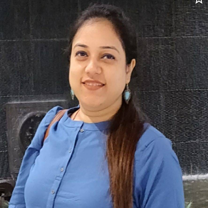 "Dr. Tamanna Vinaik Agrawal at Tamanna Woman & Child Clinic, smiling while holding medical documents."